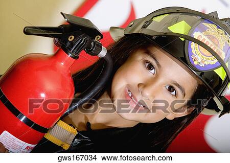 Picture - Portrait of a girl wearing a fireman costume. Fotosearch