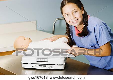 Portrait of a girl weighing a doll on a weighing scale View Large Photo Image Stock Image - Portrait of a girl weighing a doll on a weighing scale. Fotosearch