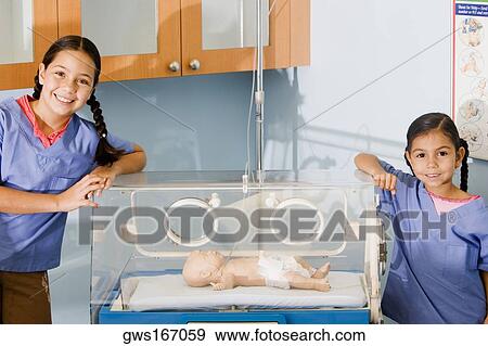 Portrait of two girls standing near an incubator View Large Photo Image Stock Photo - Portrait of two girls standing near an incubator. Fotosearch