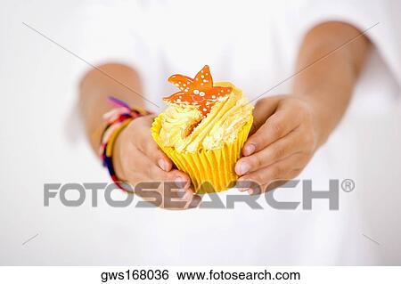 Close-up of a child's hand holding a cupcake View Large Photo Image Stock Photograph - Close-up of a child's hand holding a cupcake. Fotosearch