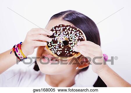 Close-up of a girl holding a donut in front of her eye View Large Photo Image Stock Photography - Close-up of a girl holding a donut in front of her eye. Fotosearch