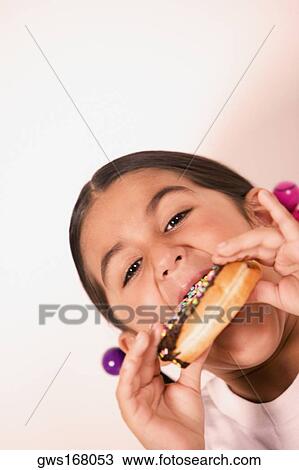 Portrait of a girl eating a donut View Large Photo Image Stock Image - Portrait of a girl eating a donut. Fotosearch