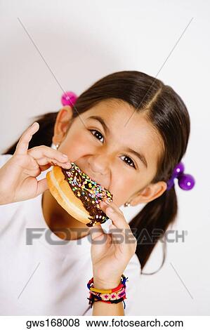 Portrait of a girl eating a donut View Large Photo Image Stock Photo - Portrait of a girl eating a donut. Fotosearch
