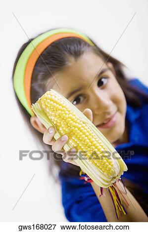 Portrait of a girl holding a corn cob View Large Photo Image Stock Photo - Portrait of a girl holding a corn cob. Fotosearch