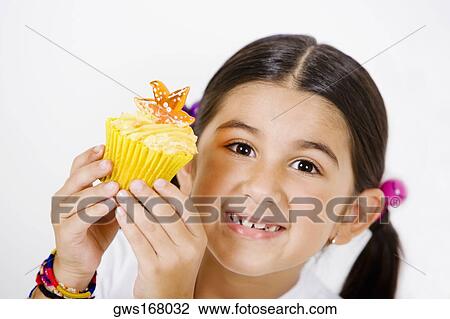 Portrait of a girl holding a cupcake View Large Photo Image Stock Image - Portrait of a girl holding a cupcake. Fotosearch