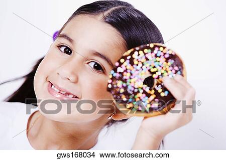 Portrait of a girl holding a donut and smiling View Large Photo Image Picture - Portrait of a girl holding a donut and smiling. Fotosearch