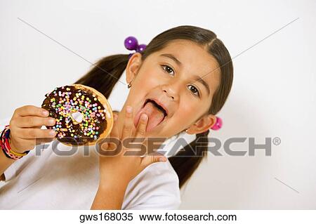 Portrait of a girl holding a donut and licking her finger View Large Photo Image Stock Photography - Portrait of a girl holding a donut and licking her finger. Fotosearch