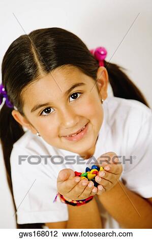 Portrait of a girl holding candies in her hands View Large Photo Image Stock Image - Portrait of a girl holding candies in her hands. Fotosearch