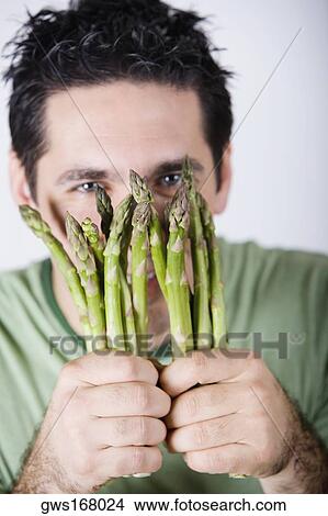 Portrait of a mid adult man holding asparagus View Large Photo Image Picture - Portrait of a mid adult man holding asparagus. Fotosearch