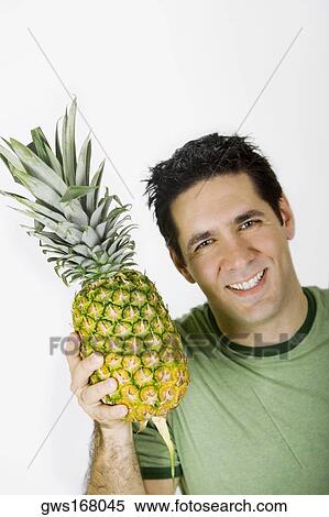 Portrait of a mid adult woman holding a pineapple and smiling View Large Photo Image Stock Photography - Portrait of a mid adult woman holding a pineapple and smiling. Fotosearch