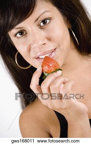 Portrait of a young woman holding a strawberry and smiling View Large Photo Image Stock Image - Portrait of a young woman holding a strawberry and smiling. Fotosearch