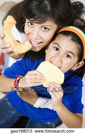 Portrait of a young woman with her daughter eating fruits View Large Photo Image Stock Image - Portrait of a young woman with her daughter eating fruits. Fotosearch