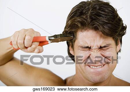 Close-up of a mid adult man pressing pliers up to his head View Large Photo Image Stock Image - Close-up of a mid adult man pressing pliers up to his head. Fotosearch