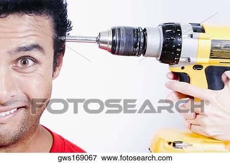 Close-up of a person's hands holding a drill machine at a young man's head View Large Photo Image Stock Photo - Close-up of a person's hands holding a drill machine at a young man's head. Fotosearch