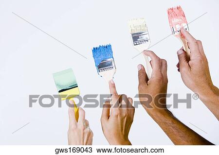 Close-up of four people's hands holding paintbrushes View Large Photo Image Stock Image - Close-up of four people's hands holding paintbrushes. Fotosearch