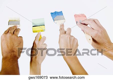 Close-up of four people's hands holding paintbrushes View Large Photo Image Stock Image - Close-up of four people's hands holding paintbrushes. Fotosearch