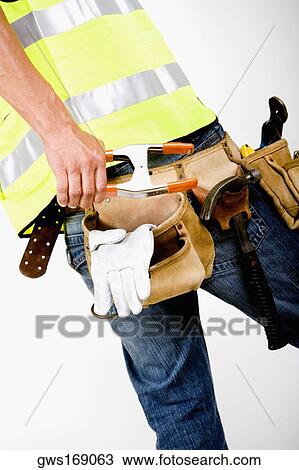 Mid section view of a man wearing a tool belt around his waist View Large Photo Image Stock Image - Mid section view of a man wearing a tool belt around his waist. Fotosearch