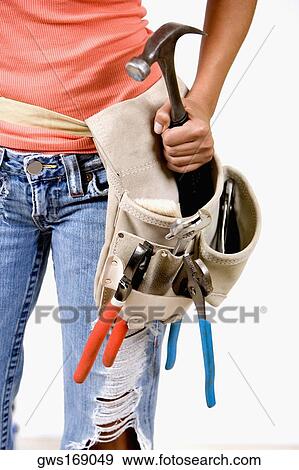 Mid section view of a person holding a hammer in a tool belt View Large Photo Image Stock Photo - Mid section view of a person holding a hammer in a tool belt. Fotosearch