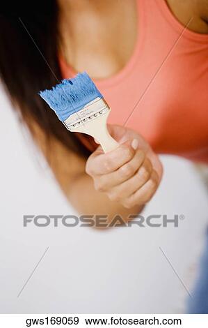Mid section view of a woman holding a paintbrush View Large Photo Image Stock Photo - Mid section view of a woman holding a paintbrush. Fotosearch
