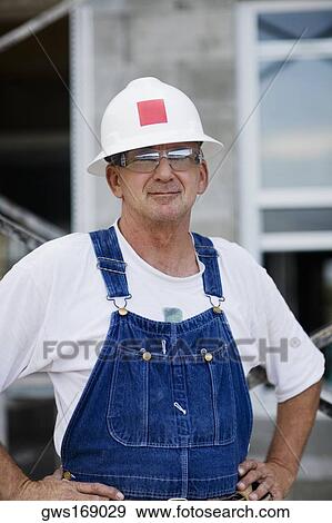 Portrait of a construction worker standing with arms akimbo View Large Photo Image Stock Photo - Portrait of a construction worker standing with arms akimbo. Fotosearch