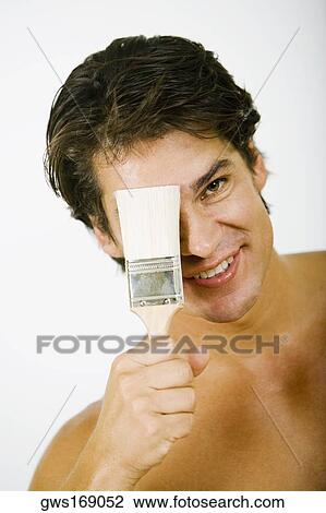 Portrait of a mid adult man holding a paintbrush in front of his face View Large Photo Image Stock Image - Portrait of a mid adult man holding a paintbrush in front of his face. Fotosearch