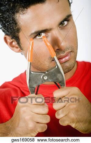 Stock Photo - Portrait of a young man holding a clamp. Fotosearch