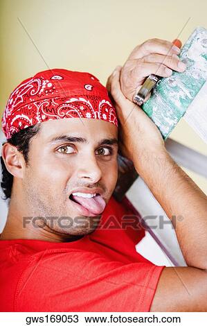 Portrait of a young man holding a pair of pliers and sticking his tongue out View Large Photo Image Stock Image - Portrait of a young man holding a pair of pliers and sticking his tongue out. Fotosearch