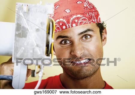 Portrait of a young man holding a circular saw and clenching his teeth View Large Photo Image Stock Photo - Portrait of a young man holding a circular saw and clenching his teeth. Fotosearch