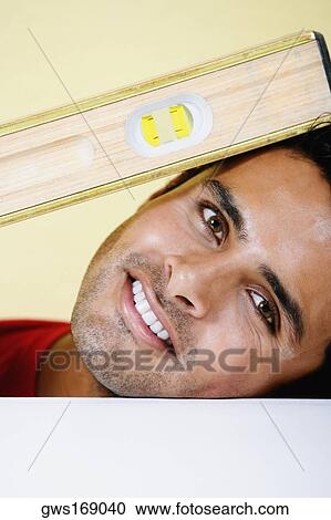Portrait of a young man smiling with a level View Large Photo Image Stock Image - Portrait of a young man smiling with a level. Fotosearch