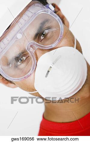 Portrait of a young man wearing a hardhat with a pollution mask and a protective eyewear View Large Photo Image Stock Photograph - Portrait of a young man wearing a hardhat with a pollution mask and a protective eyewear. Fotosearch