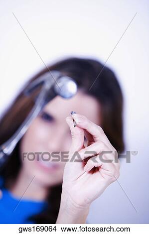 Portrait of a young woman holding a hammer and a nail View Large Photo Image Picture - Portrait of a young woman holding a hammer and a nail. Fotosearch