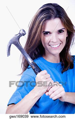 Portrait of a young woman holding a hammer View Large Photo Image Stock Photo - Portrait of a young woman holding a hammer. Fotosearch