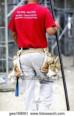 Rear view of a male architect walking and holding a spirit level View Large Photo Image Stock Image - Rear view of a male architect walking and holding a spirit level. Fotosearch