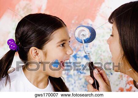 Close-up of a girl laughing with her mother holding a paint roller View Large Photo Image Stock Photo - Close-up of a girl laughing with her mother holding a paint roller. Fotosearch