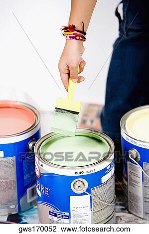 Close-up of a person's hand holding a paintbrush over a paint can View Large Photo Image Stock Image - Close-up of a person's hand holding a paintbrush over a paint can. Fotosearch