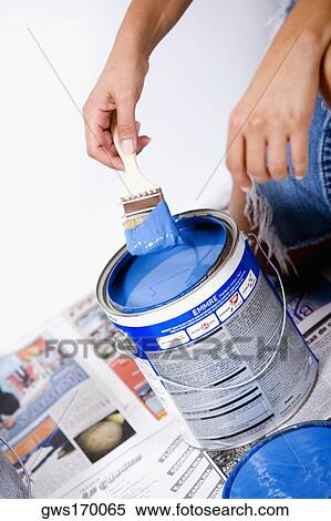 Close-up of a person's hand holding a paintbrush over a paint can View Large Photo Image Stock Photography - Close-up of a person's hand holding a paintbrush over a paint can. Fotosearch