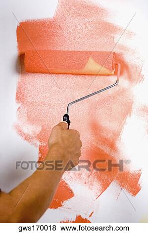 Close-up of a person's hand painting a wall with a paint roller View Large Photo Image Stock Photo - Close-up of a person's hand painting a wall with a paint roller. Fotosearch