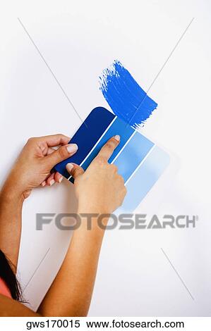 Close-up of a woman's hand holding color swatch against a wall View Large Photo Image Stock Photography - Close-up of a woman's hand holding color swatch against a wall. Fotosearch