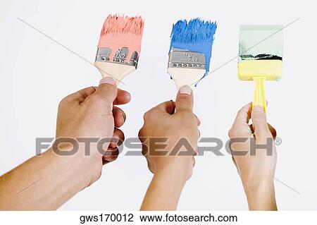Close-up of three people's hands holding paintbrushes View Large Photo Image Stock Image - Close-up of three people's hands holding paintbrushes. Fotosearch