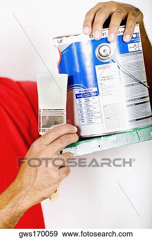 Mid section view of a man holding a paintbrush and a paint can View Large Photo Image Stock Photo - Mid section view of a man holding a paintbrush and a paint can. Fotosearch