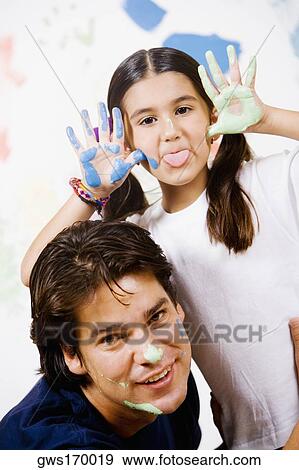 Portrait of a girl making a face with her father smiling beside her View Large Photo Image Stock Photo - Portrait of a girl making a face with her father smiling beside her. Fotosearch