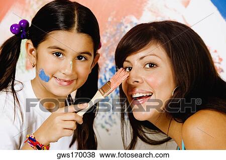 Portrait of a girl painting on her mother's nose View Large Photo Image Stock Photo - Portrait of a girl painting on her mother's nose. Fotosearch