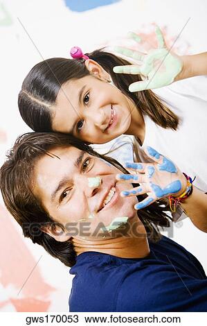 Portrait of a girl showing paint on her palms with her father smiling View Large Photo Image Stock Image - Portrait of a girl showing paint on her palms with her father smiling. Fotosearch