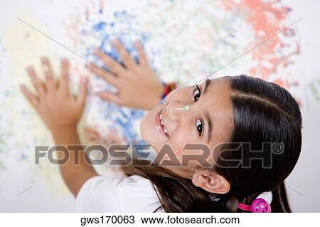 Portrait of a girl with her hands on a painted wall View Large Photo Image Stock Image - Portrait of a girl with her hands on a painted wall. Fotosearch