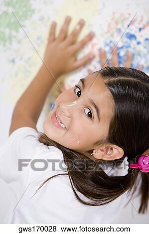 Portrait of a girl with her hands on a painted wall View Large Photo Image Stock Photo - Portrait of a girl with her hands on a painted wall. Fotosearch