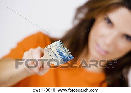 Portrait of a mid adult woman holding a paintbrush View Large Photo Image Stock Image - Portrait of a mid adult woman holding a paintbrush. Fotosearch