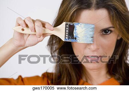 Portrait of a mid adult woman holding a paintbrush View Large Photo Image Stock Photography - Portrait of a mid adult woman holding a paintbrush. Fotosearch
