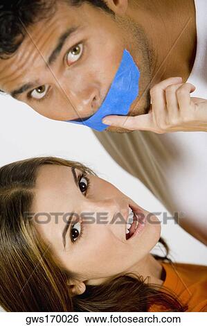 Portrait of a mid adult woman with her finger on a young man's lips View Large Photo Image Stock Photograph - Portrait of a mid adult woman with her finger on a young man's lips. Fotosearch