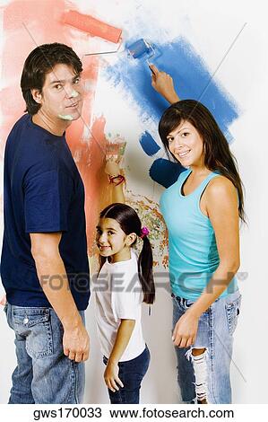 Portrait of a young man and a mid adult woman with their daughter painting a wall View Large Photo Image Stock Image - Portrait of a young man and a mid adult woman with their daughter painting a wall. Fotosearch