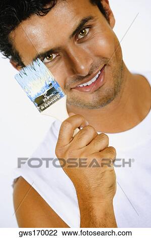 Portrait of a young man holding a paintbrush and smiling View Large Photo Image Stock Image - Portrait of a young man holding a paintbrush and smiling. Fotosearch